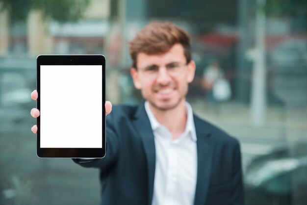 Portret biznesmen pokazuje cyfrową pastylkę z białym parawanowym pokazem