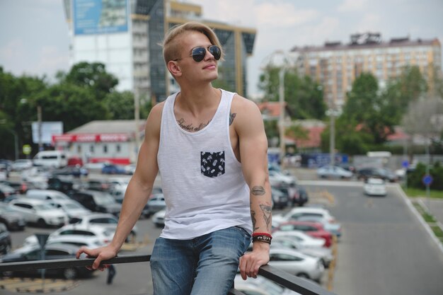 Portret blond hipster chłopiec z tatuażami i stylowe włosy