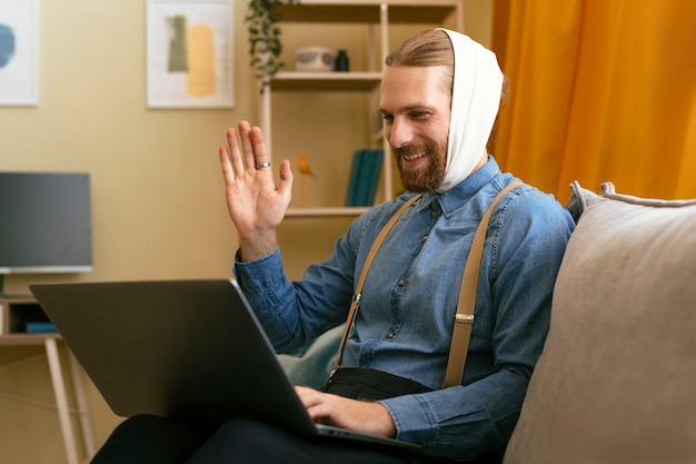 Bezpłatne zdjęcie portret brodatego mężczyzny z bandażem ucha pracującego na laptopie