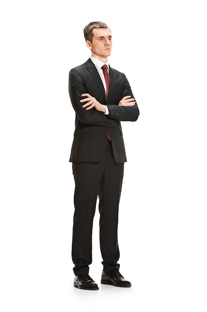 Portret całego ciała lub pełnej długości biznesmen lub dyplomata na tle białego studia. Poważny młody człowiek w garniturze, czerwony krawat stojący w biurze.