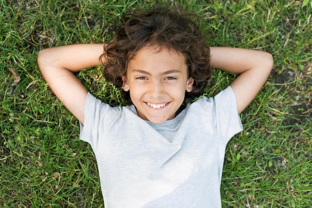 Portret chłopiec obsiadanie w trawie