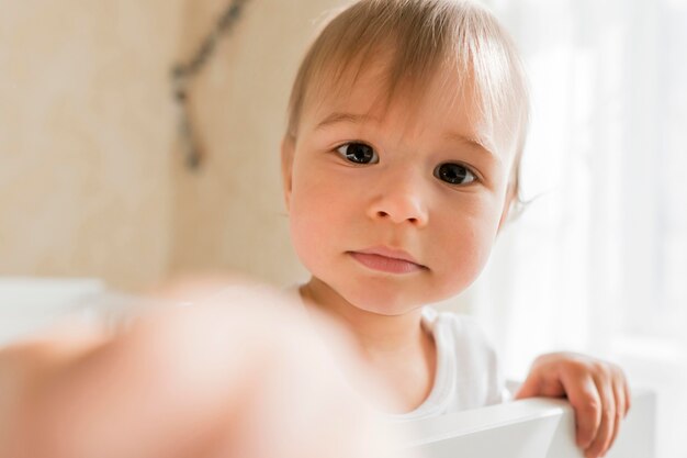 Portret cute baby siedzi w łóżeczku