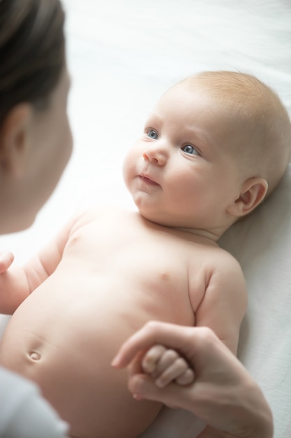 Portret cute newborn leżącego, spojrzenie na matkę