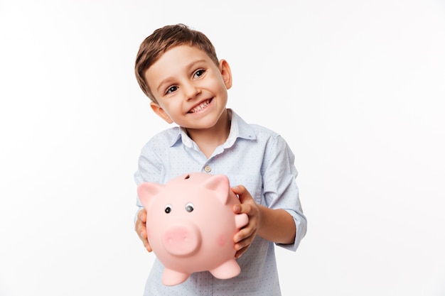 Portret czereśniowy śliczny małe dziecko trzyma prosiątko banka