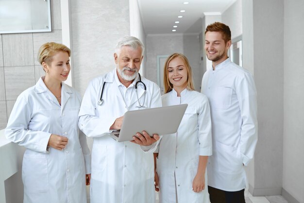Bezpłatne zdjęcie portret czterech lekarzy rozmawiających w białym mundurze