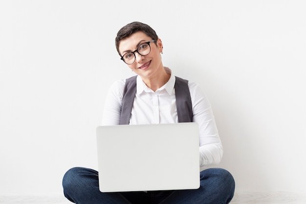 Portret dorosłej kobiety mienia laptop