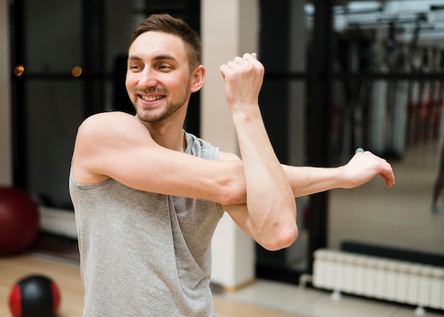 Portret dysponowanego mężczyzna rozciąganie przy gym