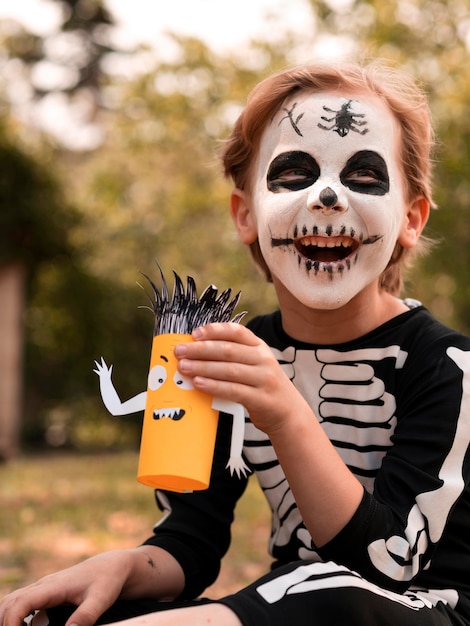 Bezpłatne zdjęcie portret dziecka z twarzą pomalowaną na halloween