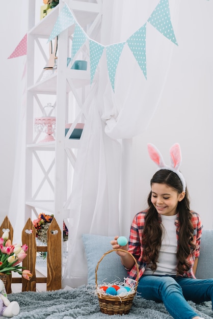 Portret Dziewczyna Patrzeje Easter Jajka Siedzi Na Dekoracyjnym łóżku