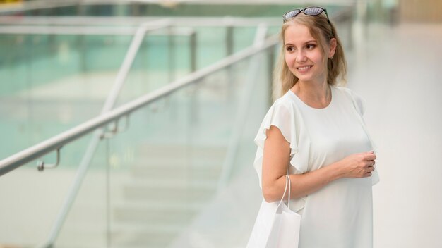 Bezpłatne zdjęcie portret eleganckiej kobiety niosącej torby na zakupy