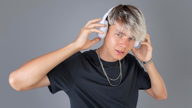 Portret fajnego nastoletniego chłopca słuchającego muzyki na słuchawkach