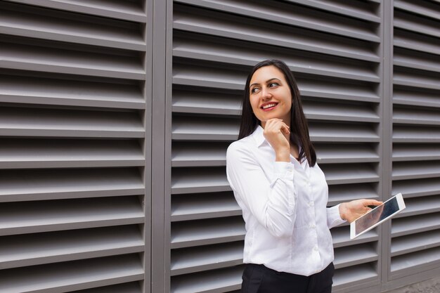 Portret flirty bizneswoman patrzeje daleko od z komputer osobisty pastylką