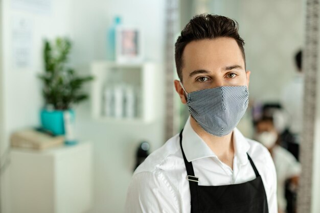 Portret fryzjera z maską ochronną w salonie fryzjerskim