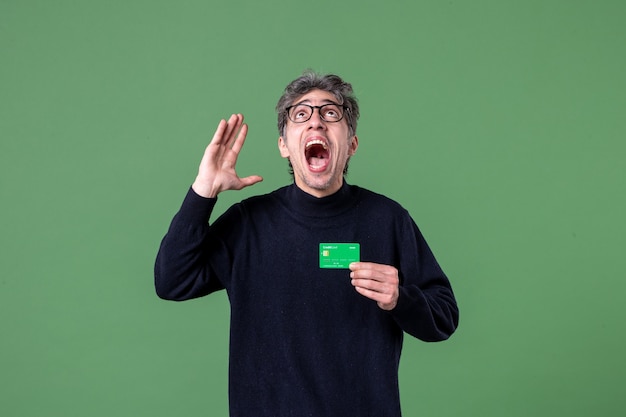 Portret Genialnego Mężczyzny Trzymającego Kartę Kredytową W Studio Strzał Zielona Powierzchnia Pieniędzy Poziomy Biznes Męski Darmowe Zdjęcia