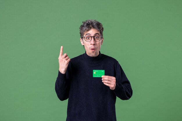 Portret genialnego mężczyzny trzymającego kartę kredytową w studio