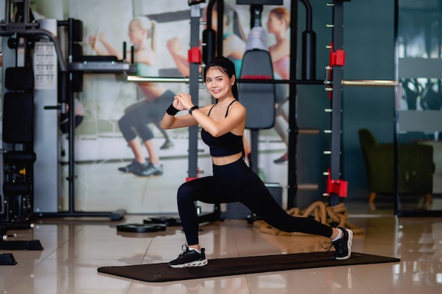 Portret kobiety fitness robi ćwiczenia rzuca na trening treningu mięśni nóg z przodu do przodu na jedną nogę krok lonża