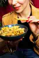 Bezpłatne zdjęcie portret kobiety jedzącej danie z poutine