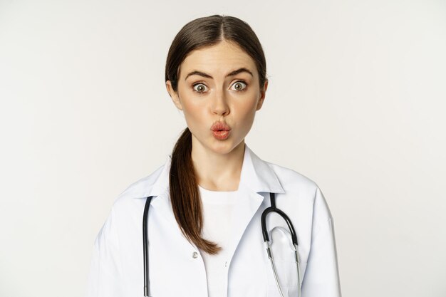 Portret kobiety lekarki wyglądającej na zaskoczoną zdziwioną reakcją zainteresowania i rozbawienia stojąc w ho...