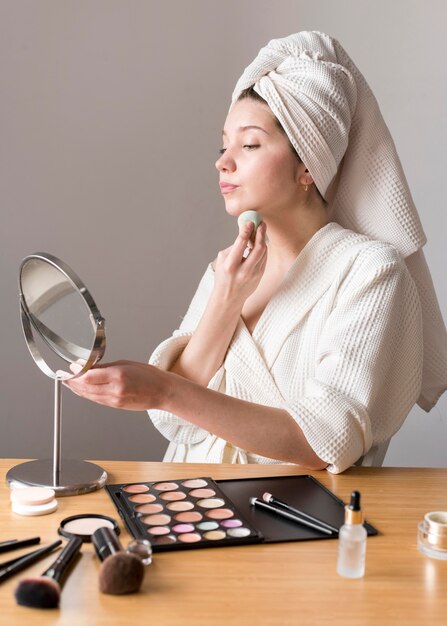 Portret kobiety makijaż z gąbką w lustrze