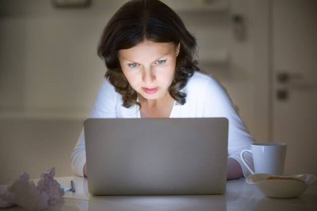 Portret kobiety na biurko pracy z laptopem, późną noc