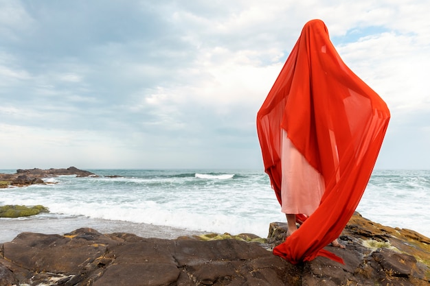 Portret kobiety na plaży z twarzą zakrytą welonem