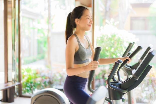 Portret kobiety piękny młody azjatykci ćwiczenie z sprawności fizycznej wyposażeniem w gym wnętrzu