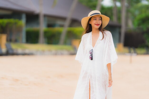 Portret kobiety piękny młody azjatykci uśmiech szczęśliwy relaksuje na plażowym dennym oceanie