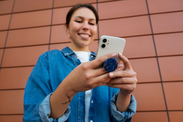 Portret kobiety za pomocą smartfona z gniazdem pop na zewnątrz