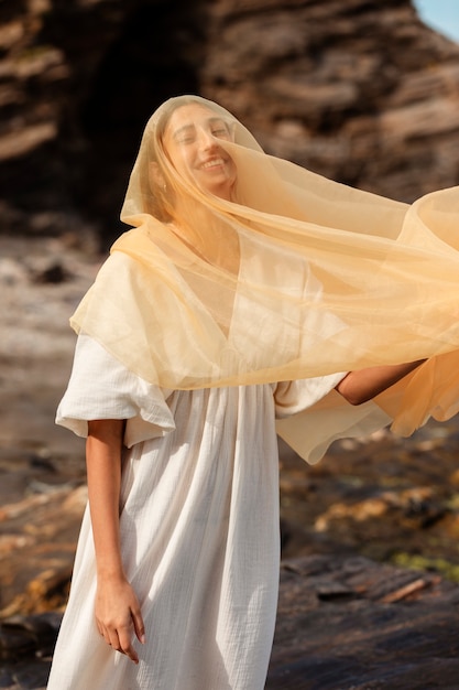 Bezpłatne zdjęcie portret kobiety zakrywającej twarz welonem na plaży