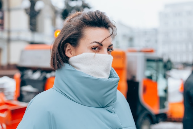 Portret kobiety zimą na tle odśnieżarki