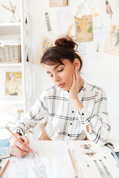 Portret kreatywnie projektant mody kobieta pracuje przy warsztatem