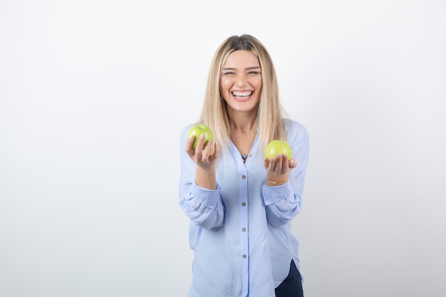 portret ładna dziewczyna model stojący i trzymając świeże jabłka.