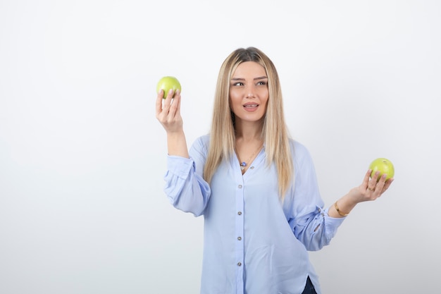 portret ładna dziewczyna model stojący i trzymając świeże jabłka.