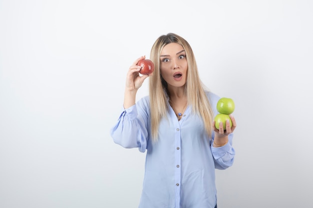 portret ładna dziewczyna model stojący i trzymając świeże jabłka.