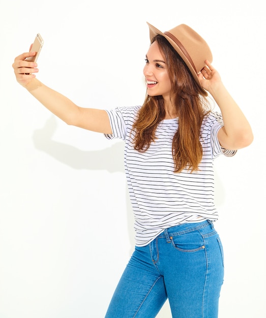 Portret ładna kobieta w lato modnisiu odziewa brać selfie odizolowywającego na biel ścianie