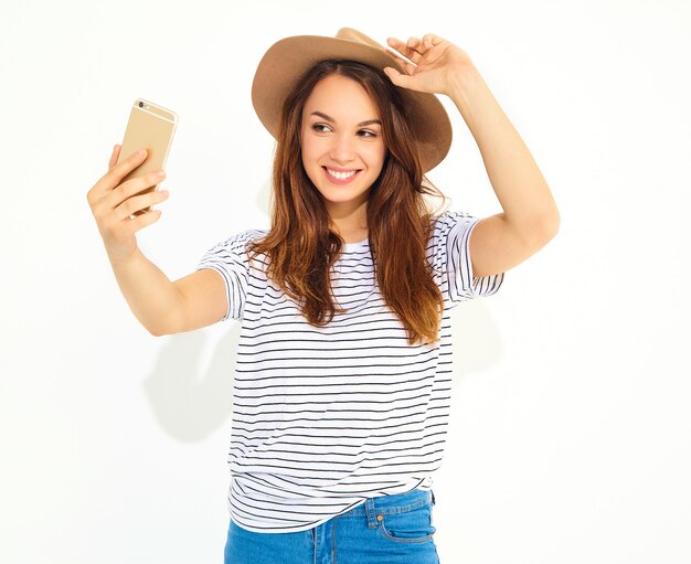 Portret ładna kobieta w lato modnisiu odziewa brać selfie odizolowywającego na biel ścianie