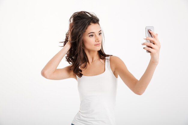 Portret ładnej kobiety ubranej w podkoszulek przy selfie