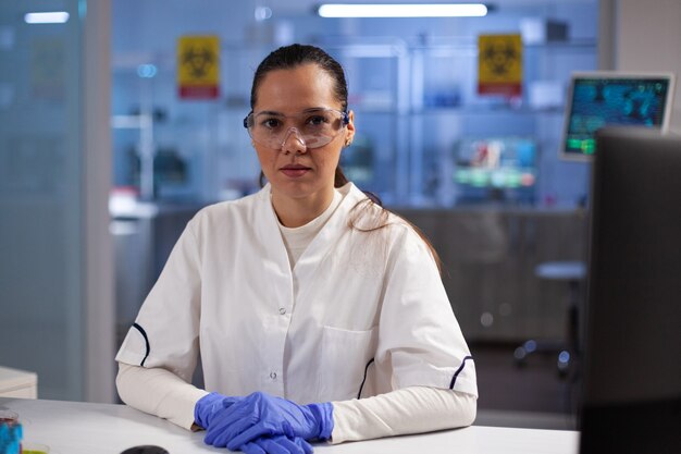 Portret lekarza kobieta lekarz siedzi przy stole podczas eksperymentu biochemicznego