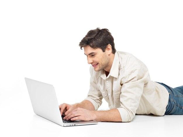 Portret leżącego szczęśliwego człowieka z laptopem zegarek na ekranie na białym tle.