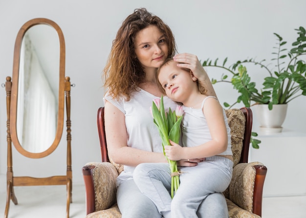 Bezpłatne zdjęcie portret matki i córki obsiadanie na ręki krześle