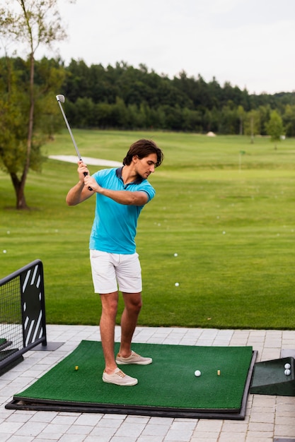 Bezpłatne zdjęcie portret męski golfowego gracza ćwiczyć