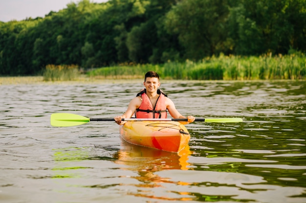 Bezpłatne zdjęcie portret męski kayaker unosi się na wodnej powierzchni