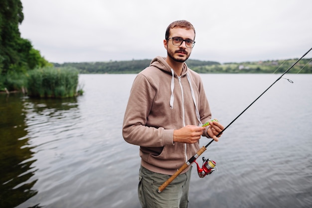 Bezpłatne zdjęcie portret mężczyzna mienia wędkarz i nęcenie