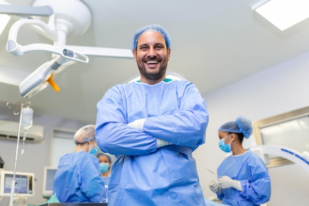 Portret Mężczyzny Chirurga W Sali Operacyjnej, Patrząc Na Kamerę Lekarz W Zaroślach I Masce Medycznej W Nowoczesnej Sali Operacyjnej Szpitala