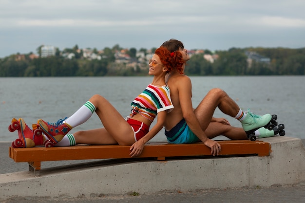 Portret mężczyzny i kobiety na plaży na rolkach w estetyce lat 80-tych