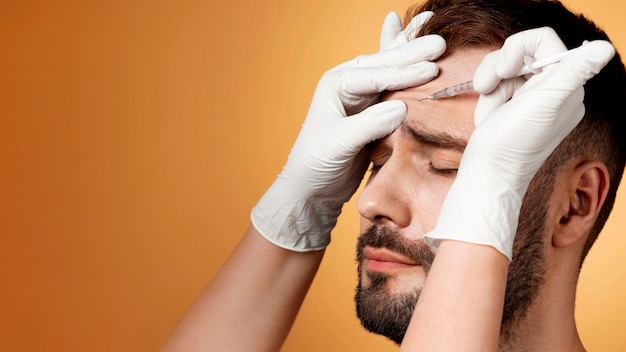 Bezpłatne zdjęcie portret mężczyzny otrzymującego ulepszenia i modyfikacje za pomocą procedur kosmetycznych.