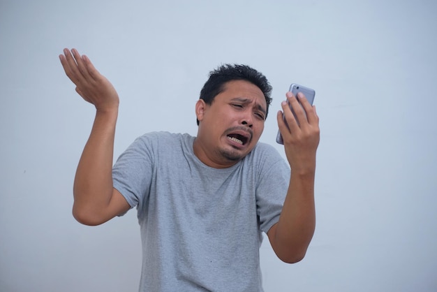 Portret Mężczyzny Płacz Podczas Patrzenia Na Telefon Premium Zdjęcia