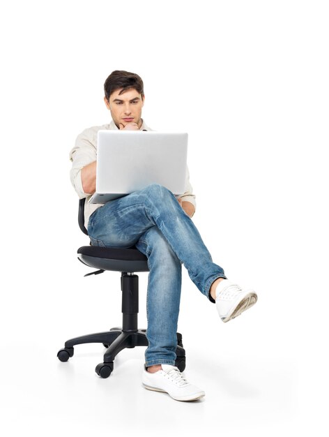 Portret mężczyzny pracującego na laptopie, siedząc na krześle