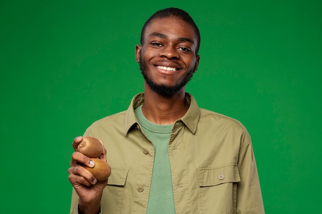 Portret mężczyzny trzymającego owoc kiwi