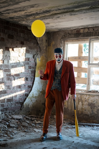 Bezpłatne zdjęcie portret mężczyzny ze strasznym makijażem klauna i balonem